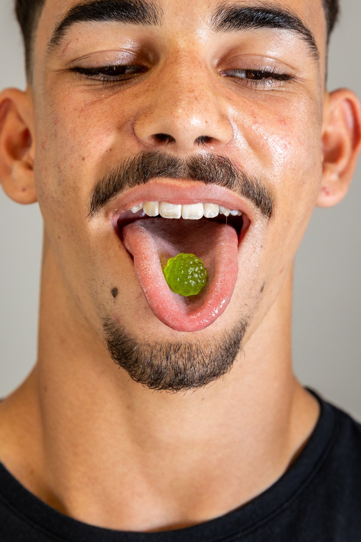 Man with an Enhancd Focus apple gummy on his tongue